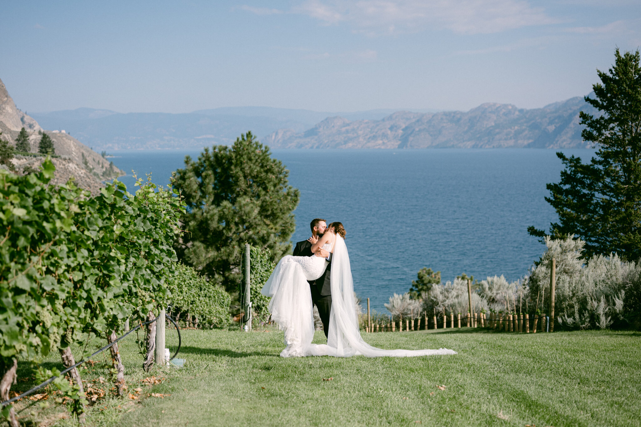 groom carries bride and kisses at kelowna wedding venue