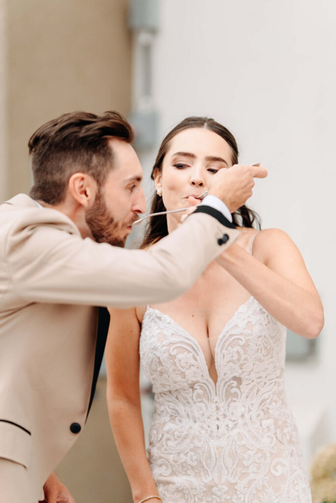 couple try their cake on their kelowna wedding day