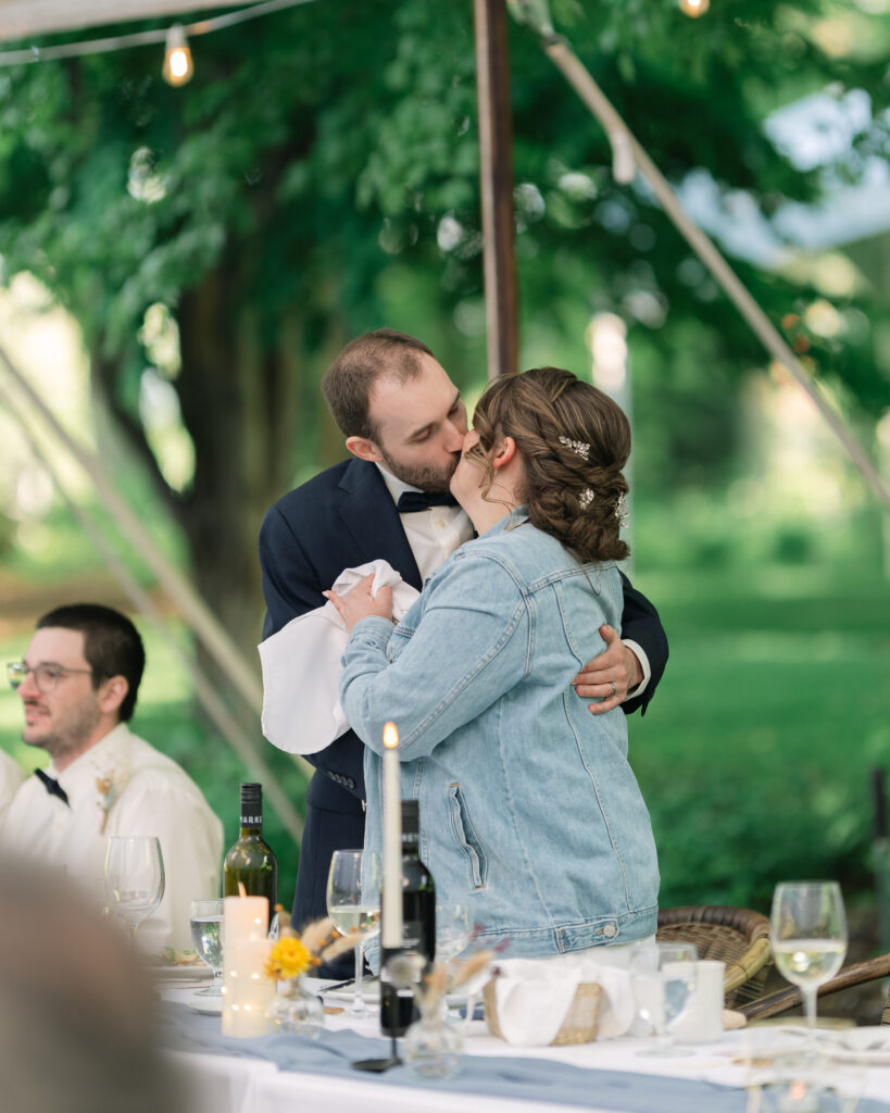 bride and groom kiss during speeches at a linden gardens wedding